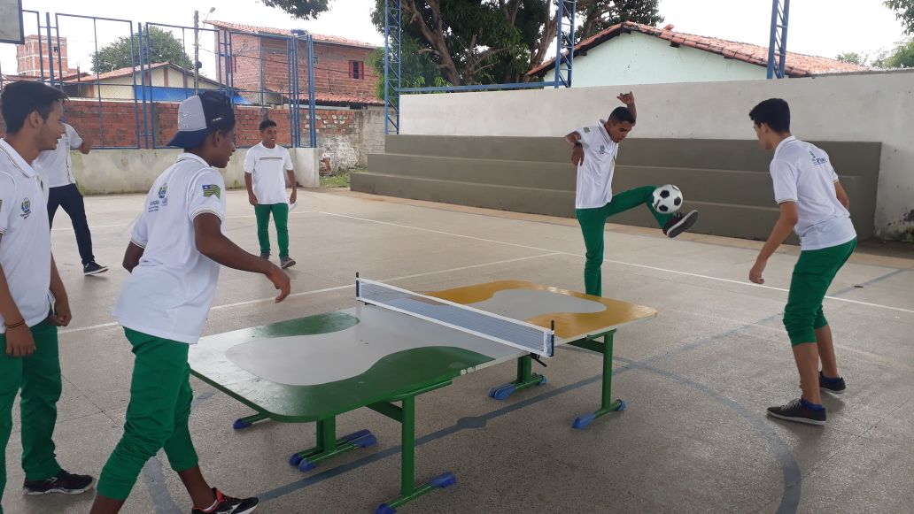 Crianças do ensino fundamental em uma sala de aula jogando futebol de mesa.  diversão durante o recreio na escola.